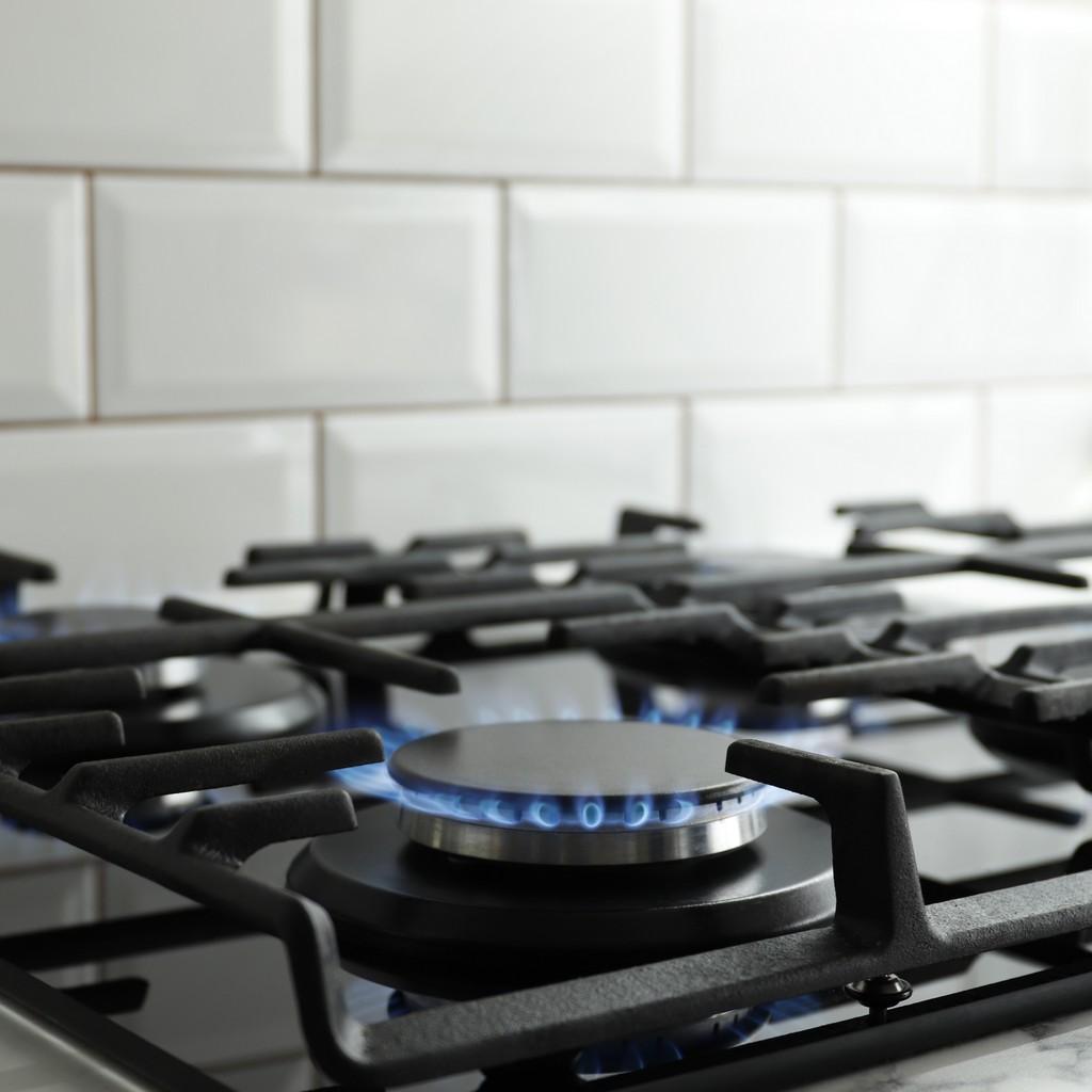 Closeup shot of blue fire from domestic kitchen stove top. Gas cooker with burning flames of propane gas. Industrial resources and economy concept.